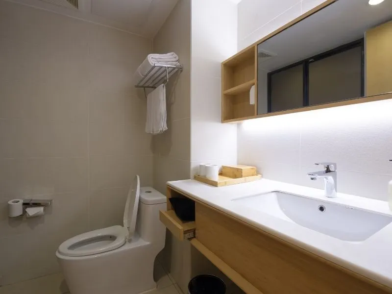 Commercial bathroom tiles from canberra tilers. White sink and wooden top shelf