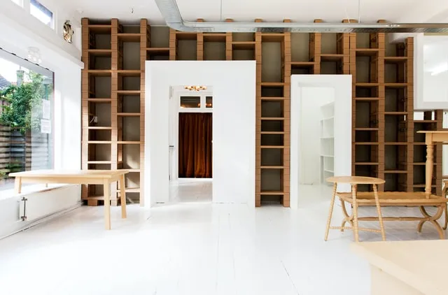 Empty room with built-in timber shelving and white painted floorboards